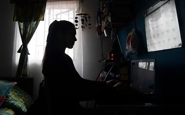 mujer joven trabajando en su casa en la oscuridad